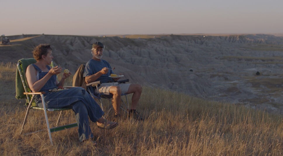 Fern (Frances Dormand) sitzt mit Nomade Dave (David Strathairn) auf Stühlen an einem Felsabhang.
