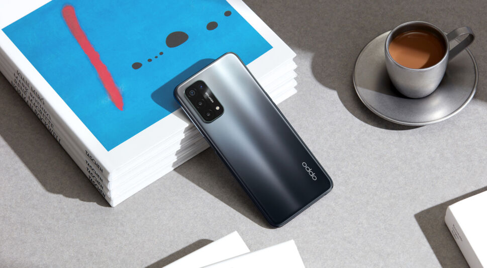 Oppo A54 5G lehnt auf Zeitschriften neben Kaffeetasse