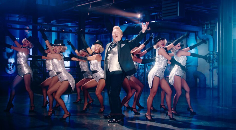 Der Teufel (Hape Kerkeling) vor einer Gruppe Tänzerinnen im Film "Der Boandlkramer und die ewige Liebe".