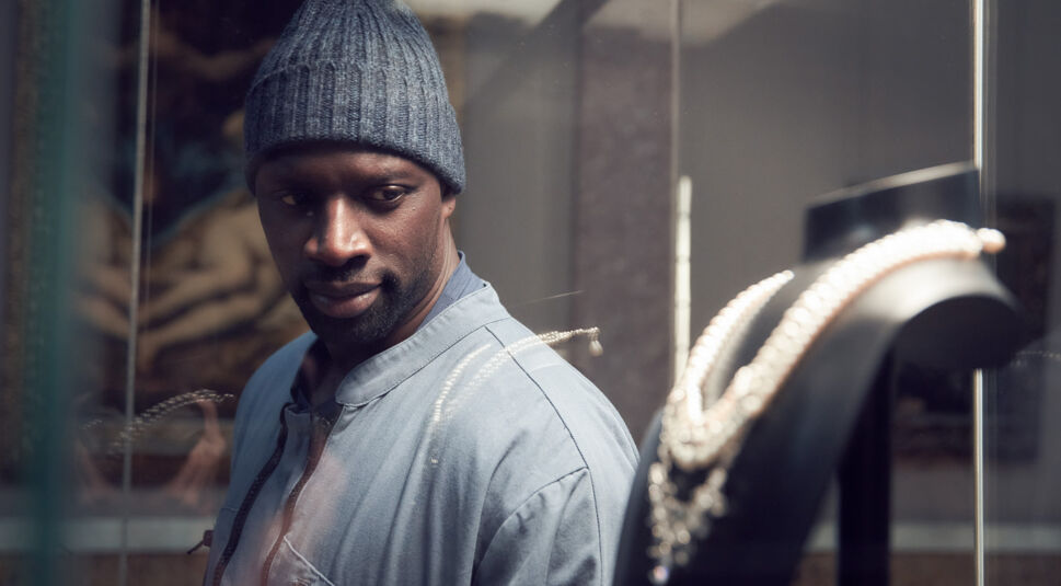 Der Meisterdieb Assane Diop schaut auf ein Collier 