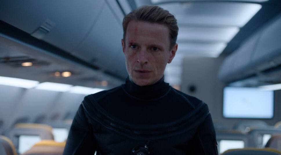 Ein Mann steht auf dem Gang eines Flugzeugs