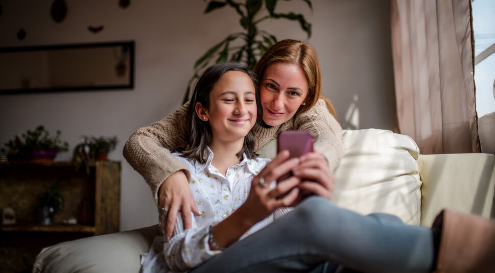 Mutter und Tochter schauen auf ein Smartphone
