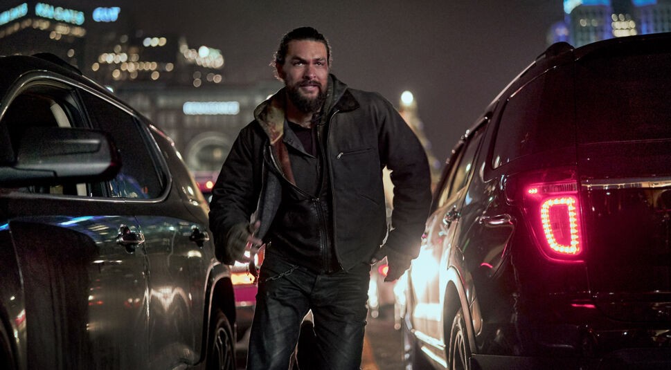 Ray Cooper (Jason Momoa) rennt zwischen zwei Autos im Thriller "Sweet Girl" hindurch.