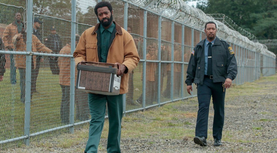 Ein Häftling läuft über den Hof eines Gefängnisses mit einem Karton voll Akten