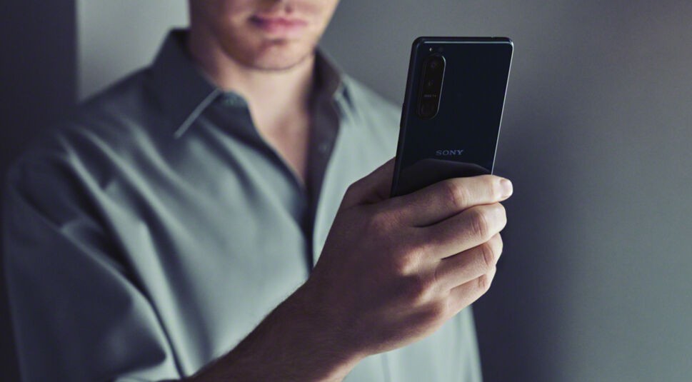 Ein Mann hält das Sony Xperia 5 III mit einer Hand hoch.