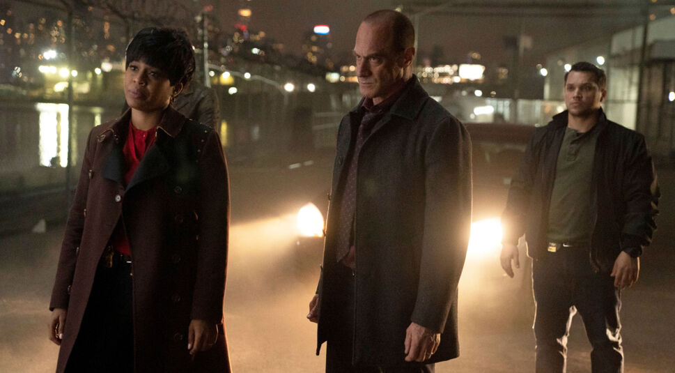 Drei Detectives aus der Serie Law & Order: Organized Crime stehen auf der Straße vor einem eingeschalteten Auto