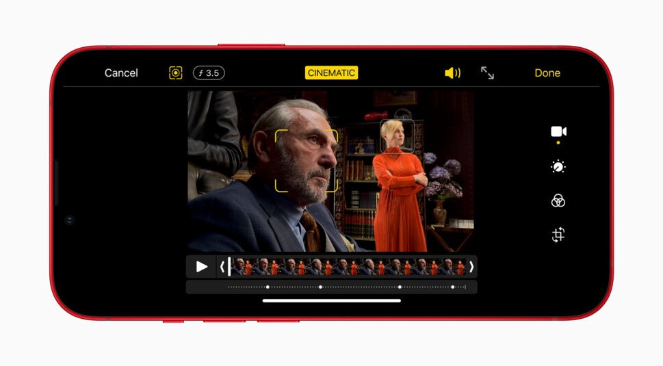 Der Kinomodus des iPhone 13 mini und iPhone 13 zeigt einen Mann nah sowie eine Frau im Hintergrund.