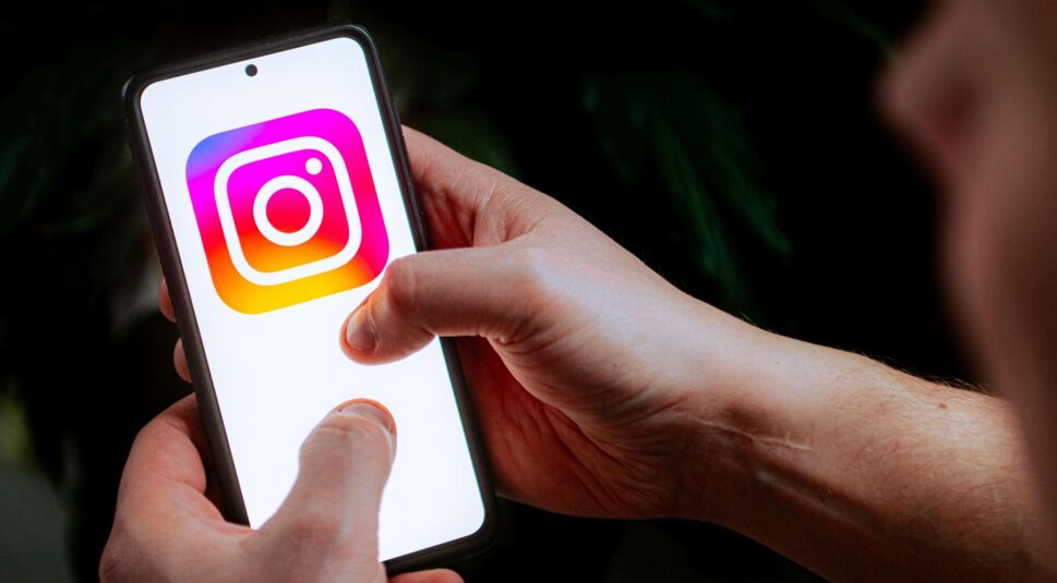Mann tippt auf das Instagram-Logo auf einem Smartphone