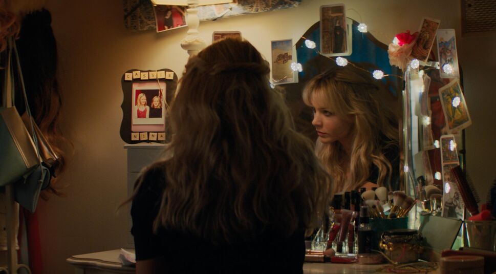 Eine Frau sitzt vor ihrem Schminkspiegel und macht sich zum ausgehen fertig