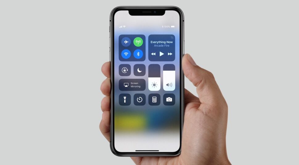 Hand hält iPhone X vor grauem Hintergrund