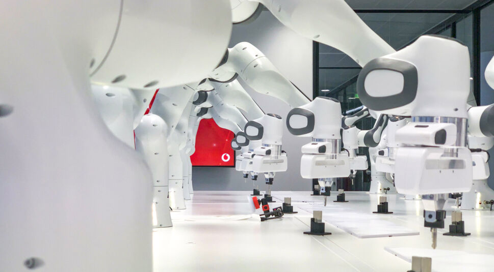 Mehrere weiße Roboter kommunizieren über das 5G Edge Computing von Vodafone in Echtzeit.