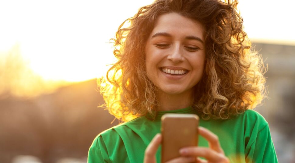 Frau schaut auf ihr iOS-Smartphone.
