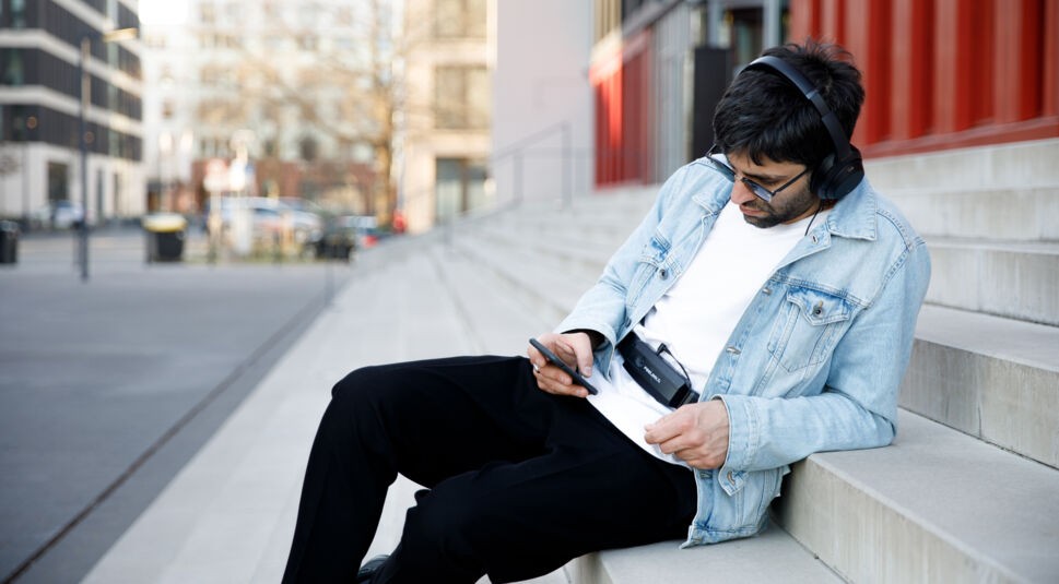 Mann mit Gaming Gadgets auf Stufen