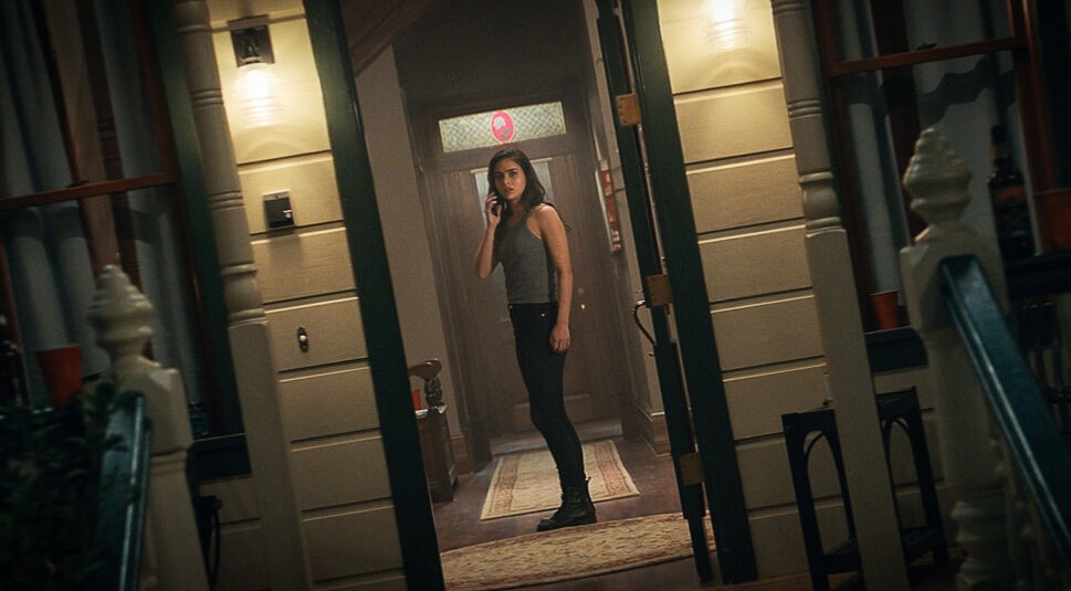 Scream 5 Sam (Melissa Barrera) steht im Flut mit Telefon am Ohr und schaut erschrocken