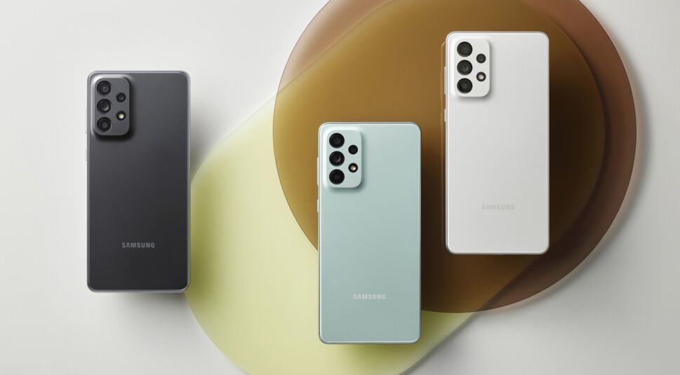 Drei Samsung-Smartphones rückseitig nebeneinander vor grauem Hintergrund mit bunten Kreisen