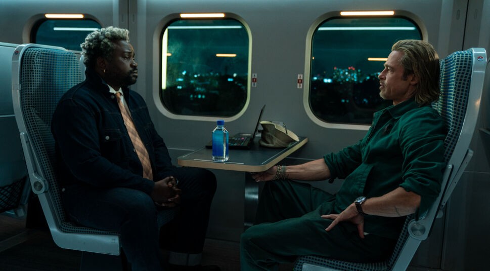 Bryan Tyree Henry und Brad Pitt sitzen sich in einem Hochgeschwidigkeitszug gegenüber im Film Bullet Train.