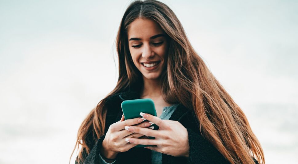 Frau schaut auf ihr Smartphone.