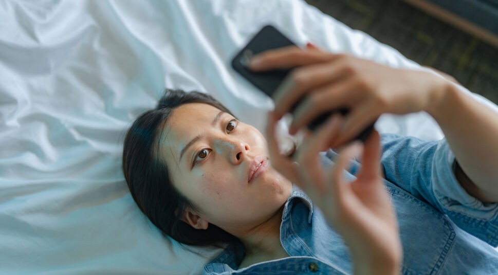 Trauernde Frau mit Handy