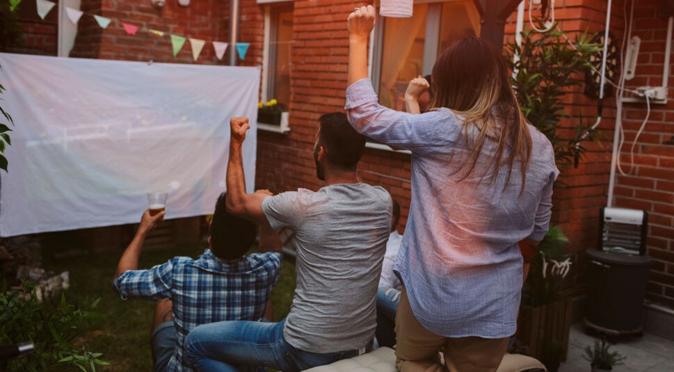 Freunde beim gemeinsamen Fußballgucken im Garten