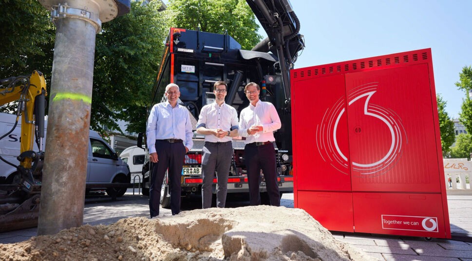 Drei Personen stehen vor einem Saugbagger