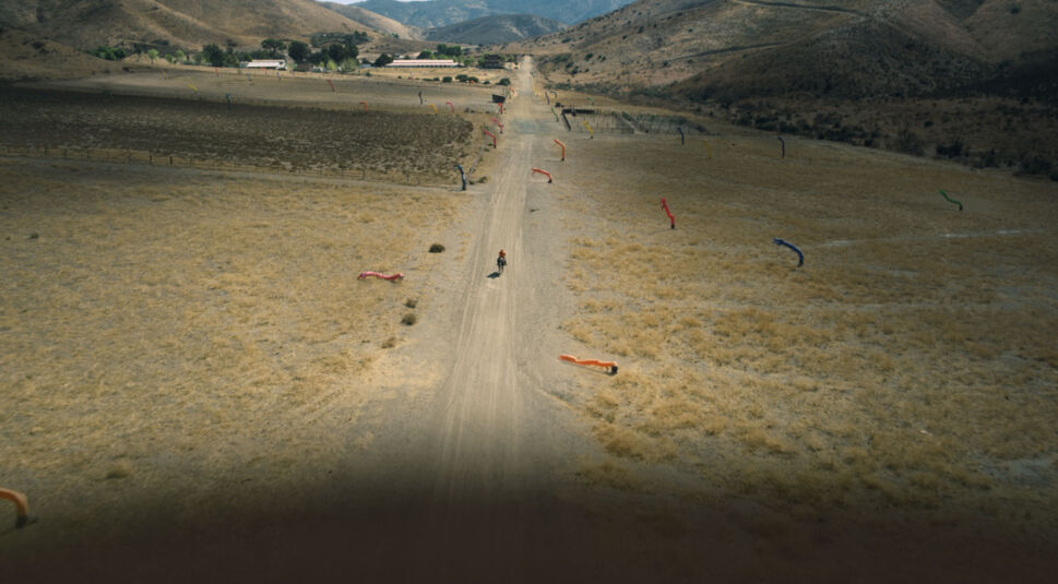 Ein Reiter flieht vor einem großen Flugobjekt, das einen Schatten auf die Wüste wirft im Film Nope