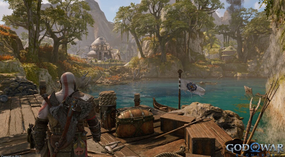 Kratos steht auf einem Steg, der in einen Fluss hineinragt in God of War Ragnarök