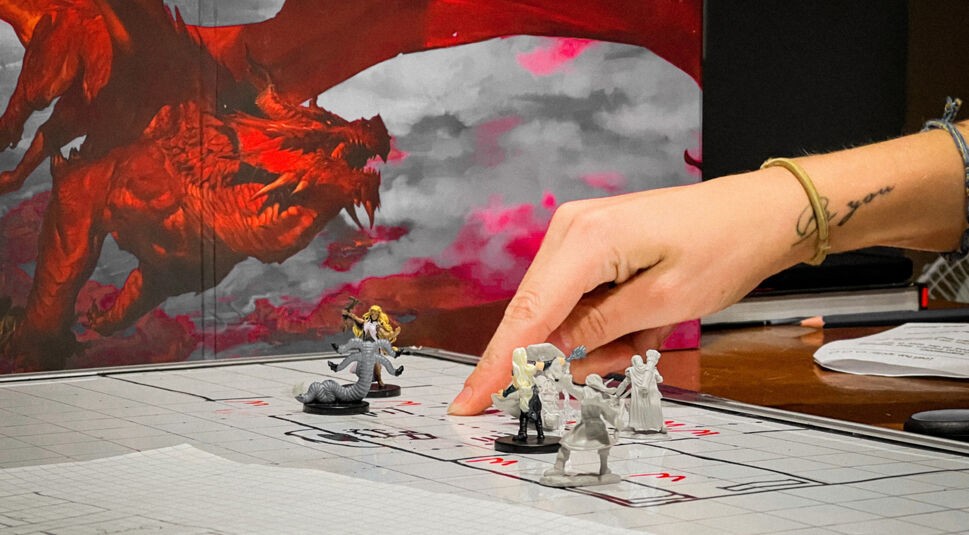 Eine Person bei einer Partie Dungeons & Dragons mit Spielfiguren