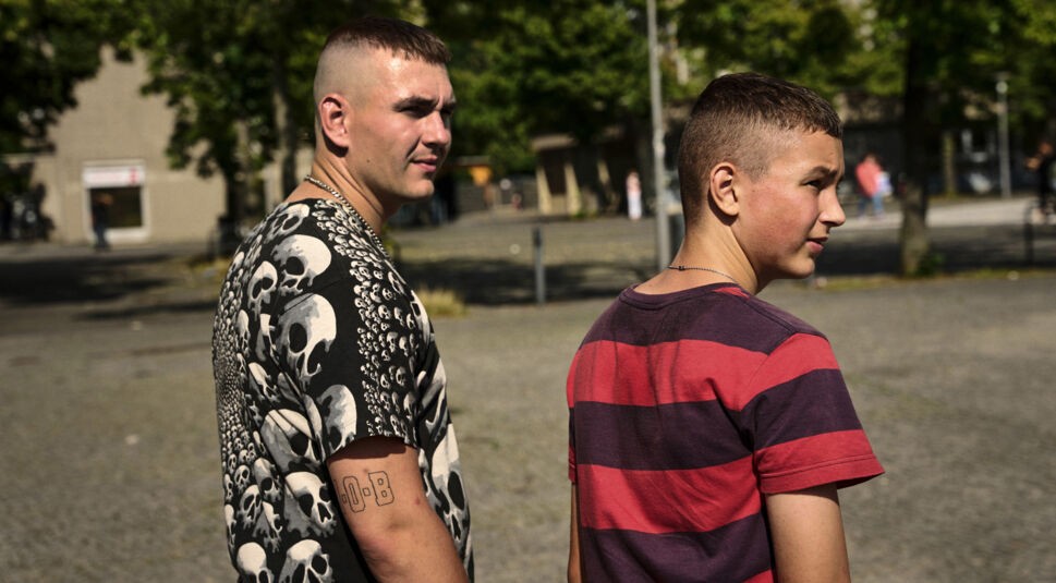 Lukas‘ (Levy Rico Arcos) und sein älterer Bruder Marco (Luvre47) spazieren durch den Plattenbau