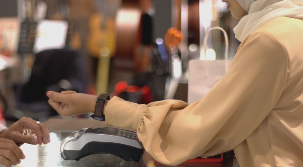 Frau bezahlt via Smartwatch an der Kasse