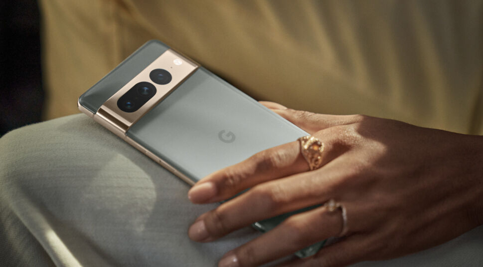 Eine weibliche Hand mit ringen hält das Handy Pixel 7 Pro eng am sitzenden Bein