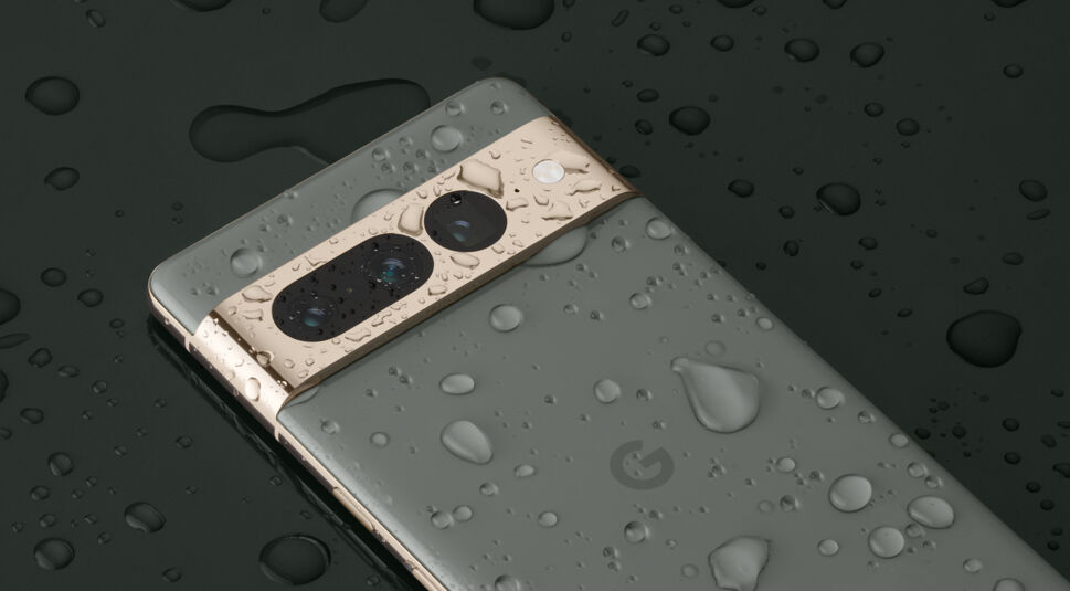 Das graue Smartphone Pixel 7 Pro liegt auf dunklem Untergrund, Wassertropfen perlen vom Gehäuse ab