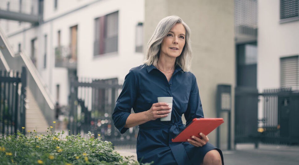 Frau hat Tablet und Kaffee in den Händen