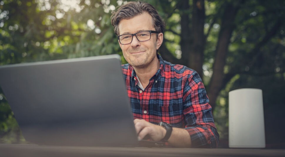 Mann sitzt mit Laptop und GigaCube im Garten