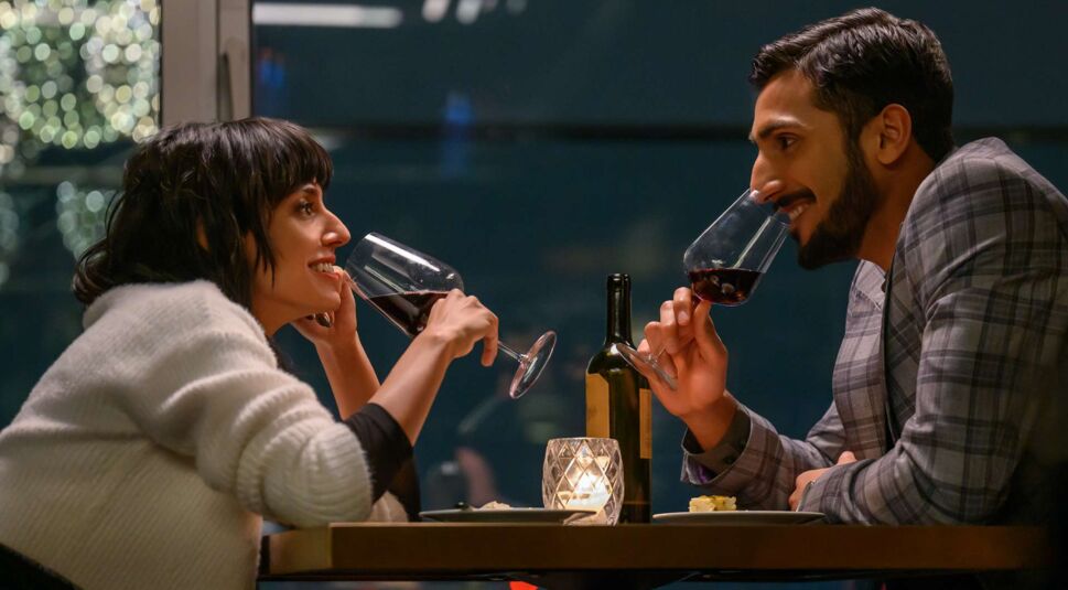Ritu Arya als Lena und Akshay Khanna als Salim bei einem Glas Wein.