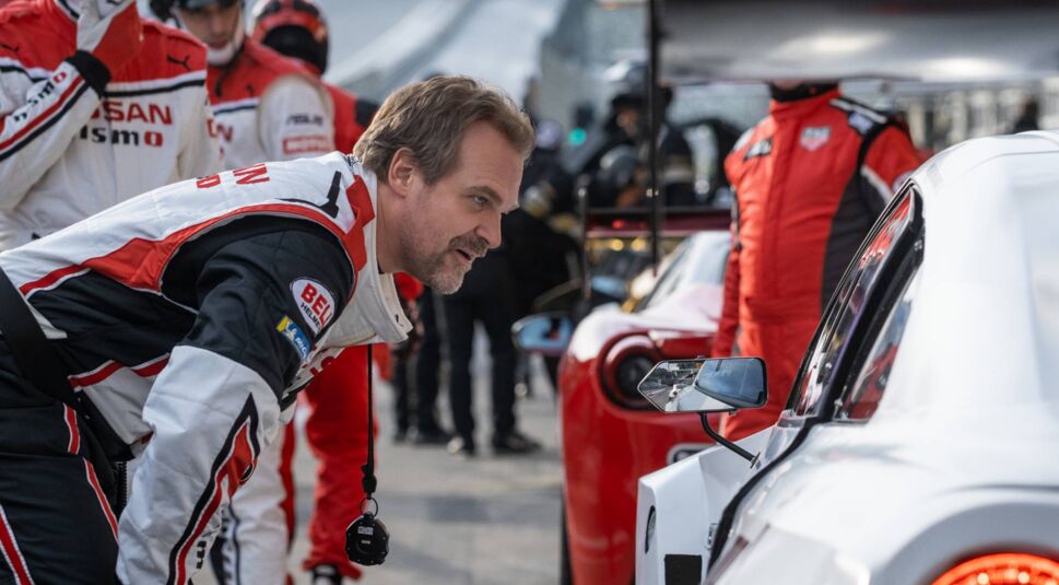 David Harbour schaut in das Fenster eines Sportwagens