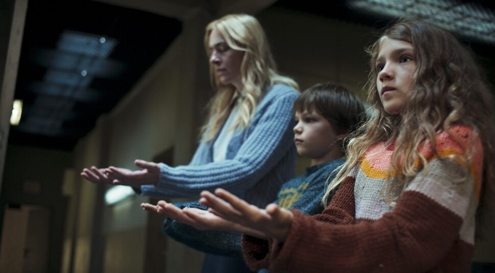 Eine Frau, ein junge und ein Mädchen strecken die Hände mit den Handflächen nach oben aus