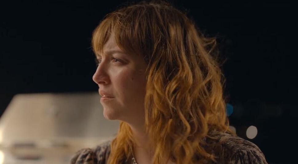 Alt-Text: Ein Szenenfoto aus dem Netflix-Film „Tödliche Einladung“ zeigt Schauspielerin Regina Blandón mit braunen, langen Haaren und einem skeptischen Blick.