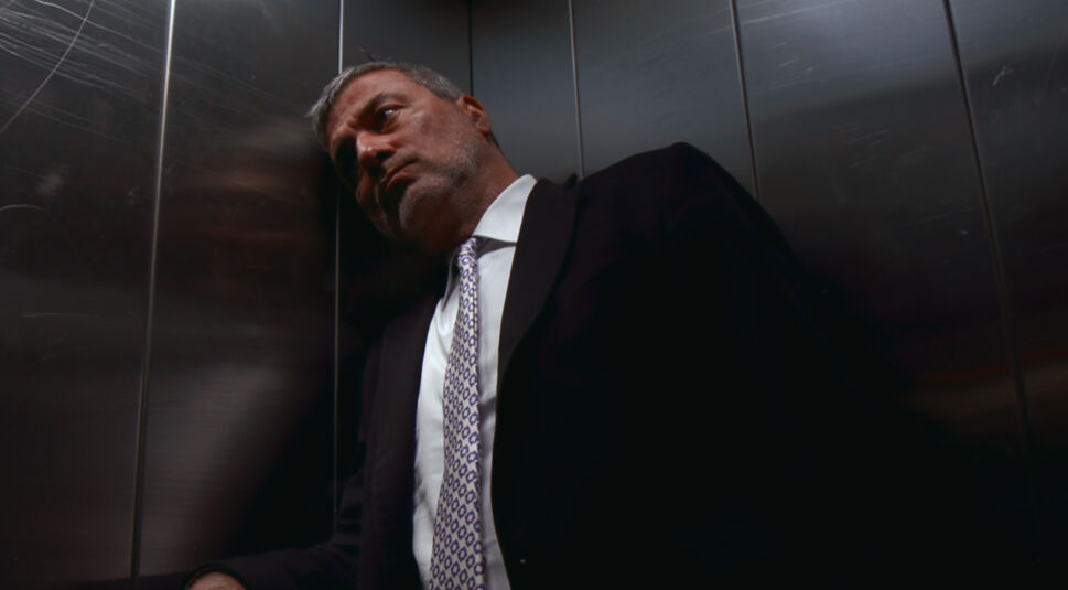 Bad Surgeon - Liebe unter dem Messer: Ein Mann mittleren Alters mit schwarzem Anzug steht in der Ecke eines Fahrstuhls und legt besorgt den Kopf an die Wand.