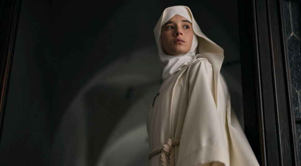 Aria Bedmar in Die Todesschwester: Junge Frau in einem Novizinnen-Gewand der Nonnen steht in einem dunklen Gang.