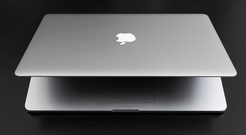 Ein Macbook auf einem schwarzen Holztisch