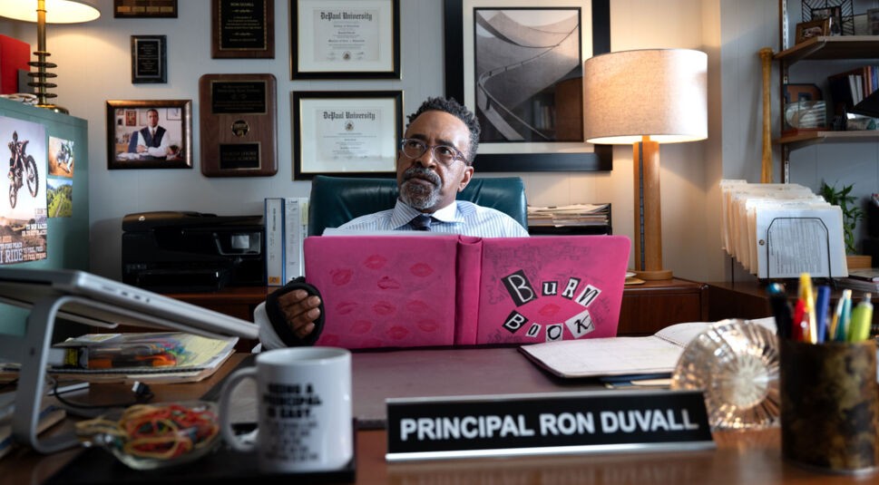 Tim Meadows sitzt mit dem Burn Book an seinem Schreibtisch