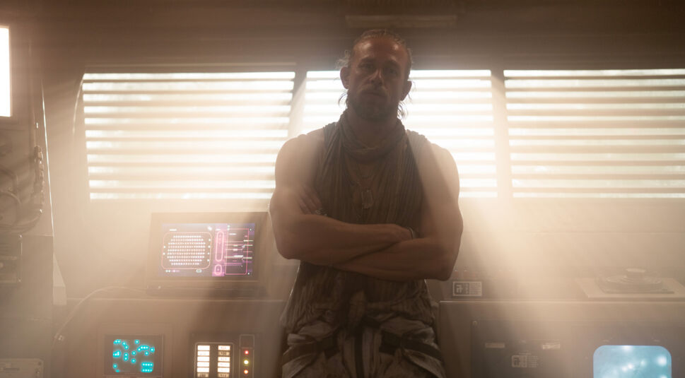 Kai (Charlie Hunnam) lehnt mit dem Rücken an einer Kommandozentrale. Von hinten scheint Licht durch die Rollos.