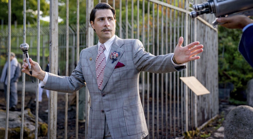 Jason Schwartzman steht als Lucky Flickerman vor der Hungerspiele-Arena