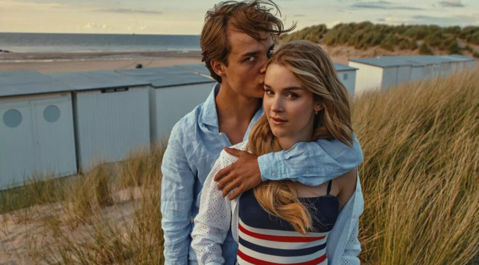 Knokke Off bei Netflix: Ein junger Mann hält eine junge Frau am Strand im Arm und küsst sie auf die Schläfe. 
