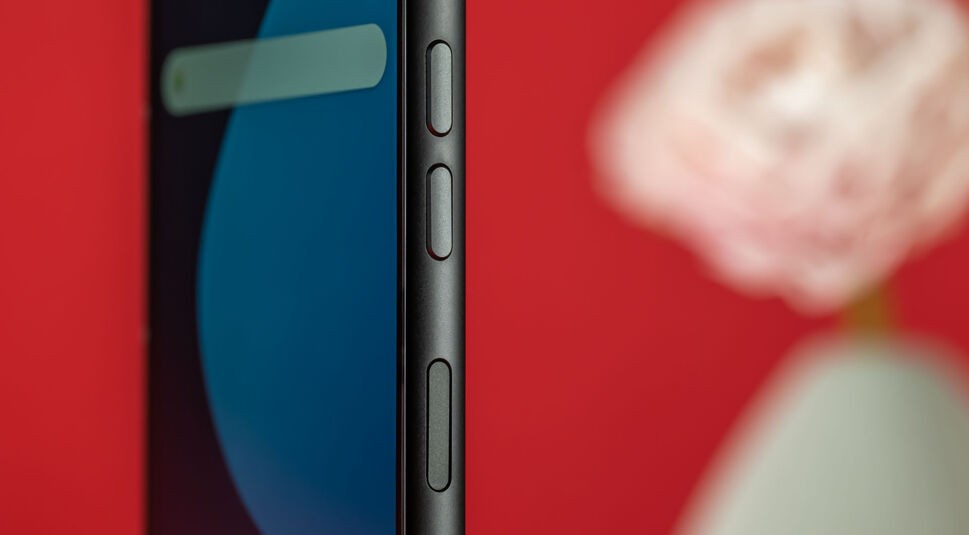 Das Fairphone 5 in schräger Ansicht mit Buttons an der Seite vor rotem Hintergrund