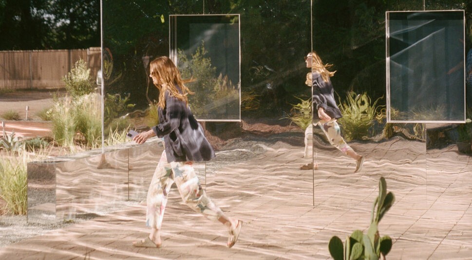 Emma Stone als Whitney läuft vor einem verspiegelten Passivhaus entlang in der Serie The Curse