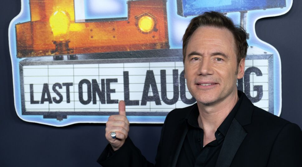 Michael Bully Herbig posiert vor dem LOL-Logo.