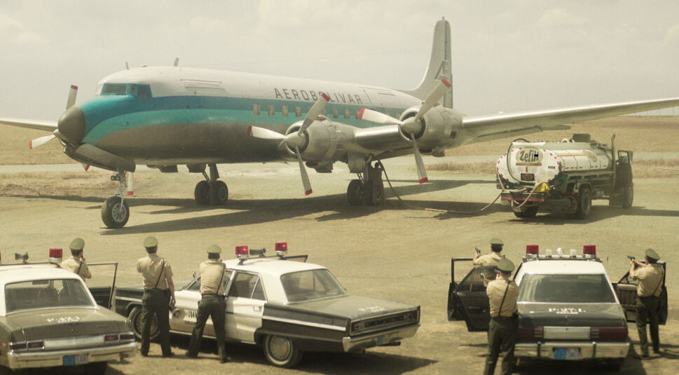 Szenenbild aus der Serie Die Entführung des Flugs 601: Ein Flugzeug, das von Polizisten umstellt ist.