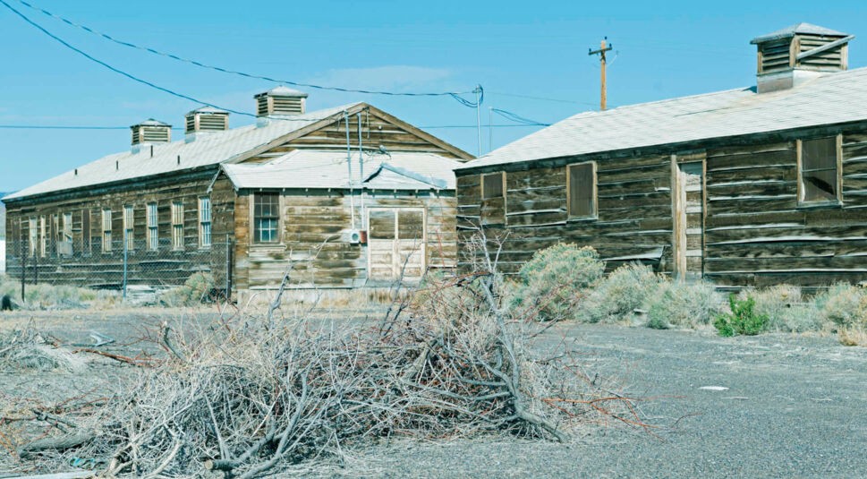 Verfallene Holzhäuser in einer Wüstenlandschaft