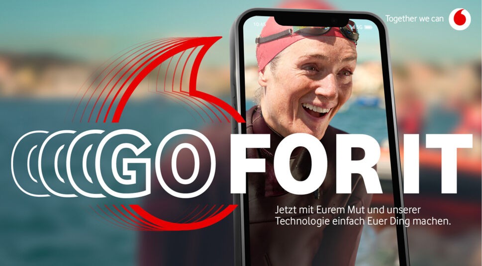 Auf diesem Bild zur neuen Vodafone Werbung 2024 ist eine Schwimmerin zu sehen, die erfreut schaut. Ihr Gesicht ist durch ein Smartphone zu sehen und sie beugt sich am Beckenrand hervor.